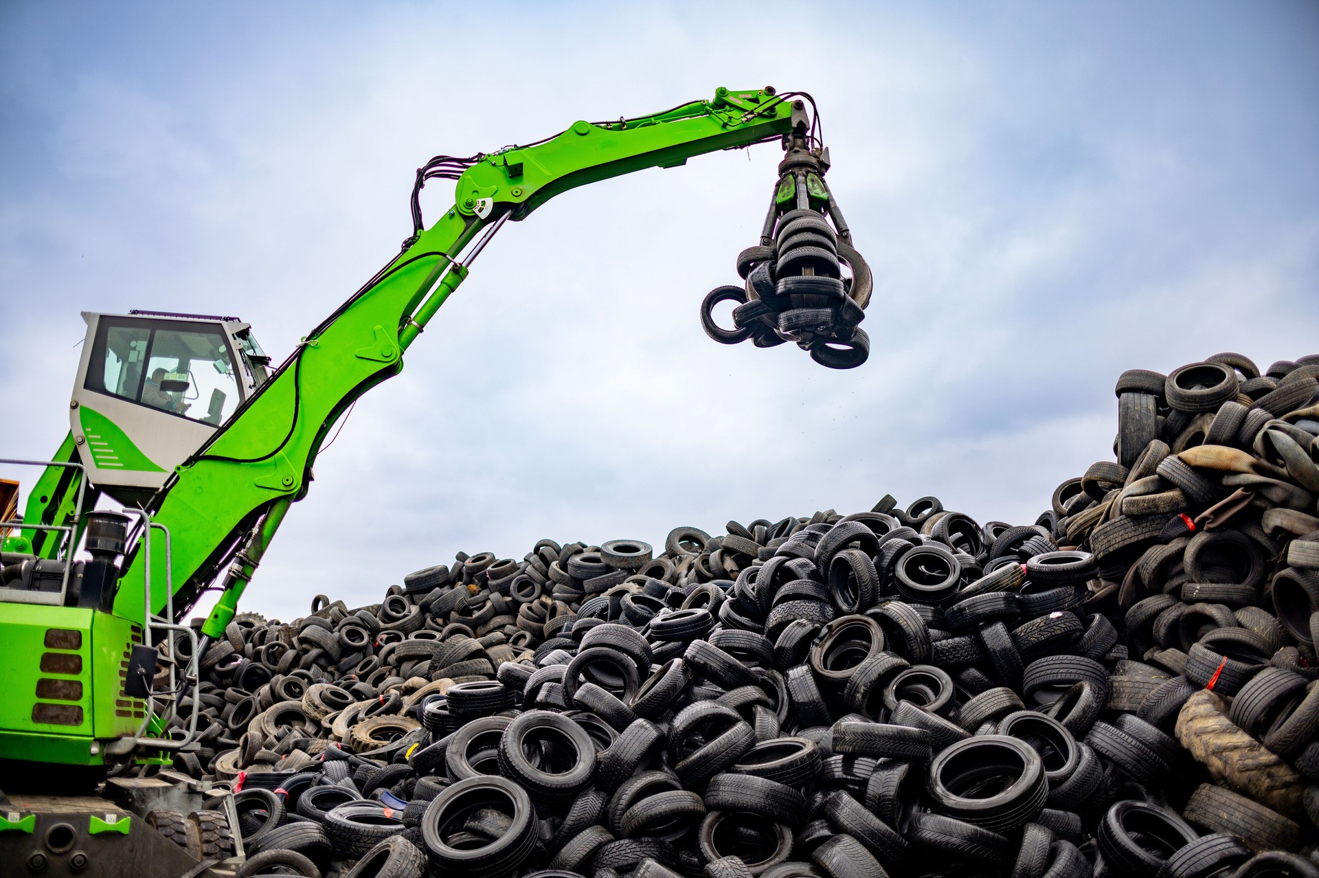 Modern material handler lifting and processing scrap tires
